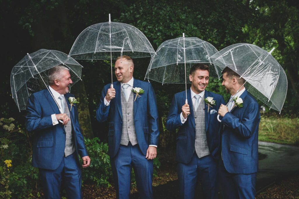Groomsmen talking in the rain in Mirfield