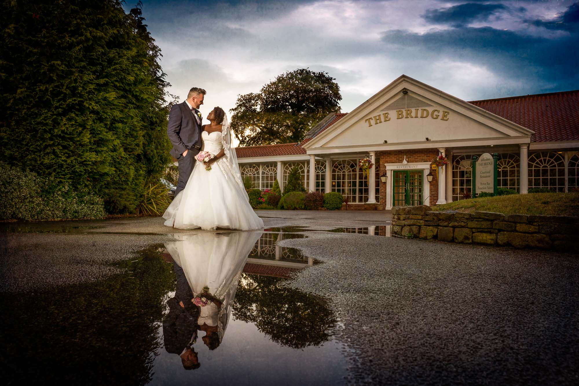 Bride and groom in water reflection at The Bridge Inn in Wetherby