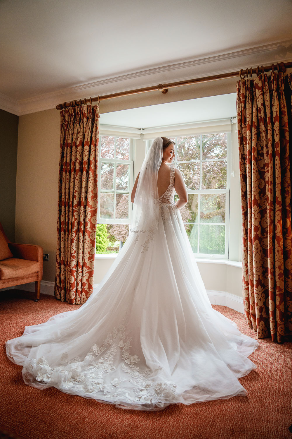 Bride in dress near window